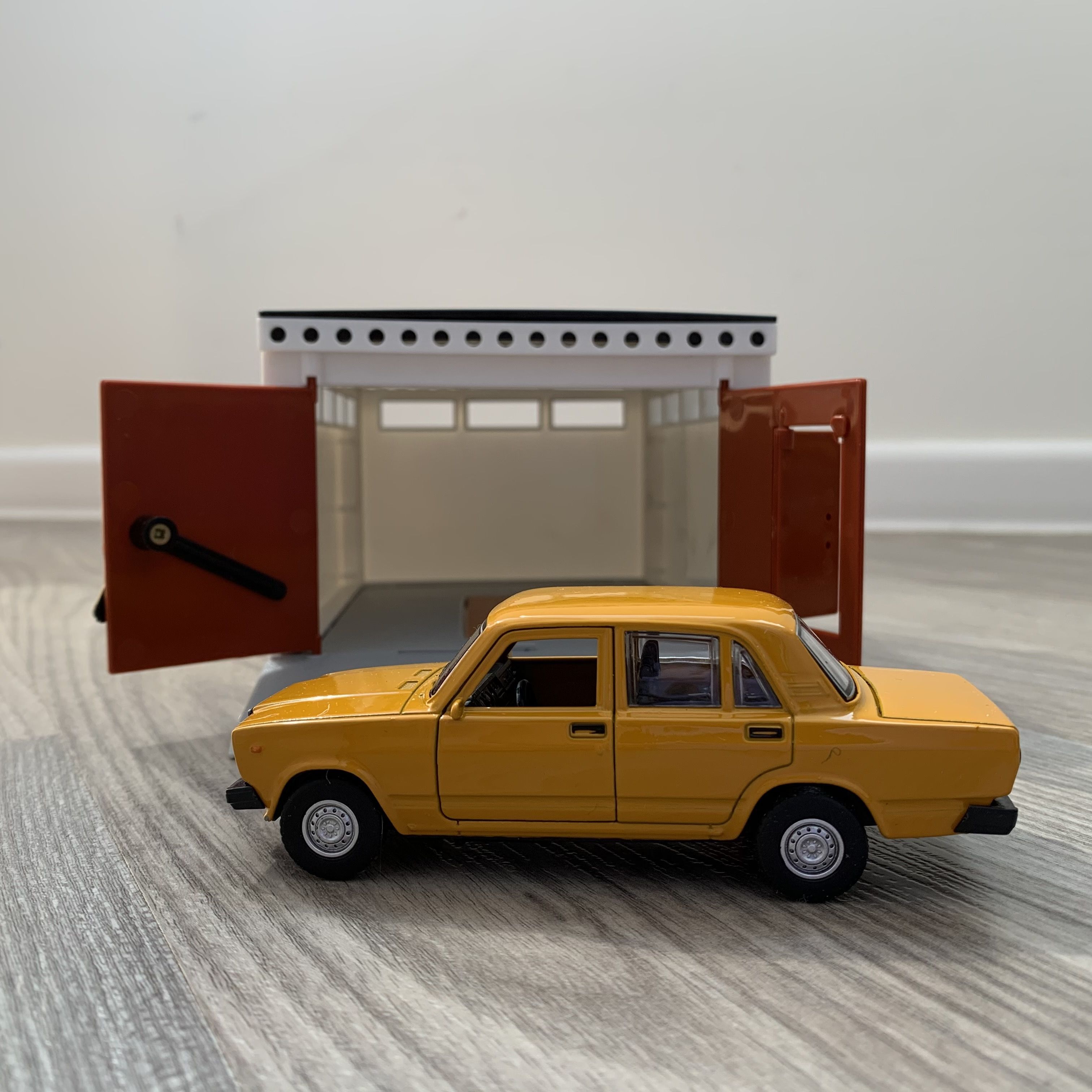 Гараж с распашными воротами и металлическая машинка 12 см модель ВАЗ 2107 инерция, 2 откр. двери и багажник - оранжевая