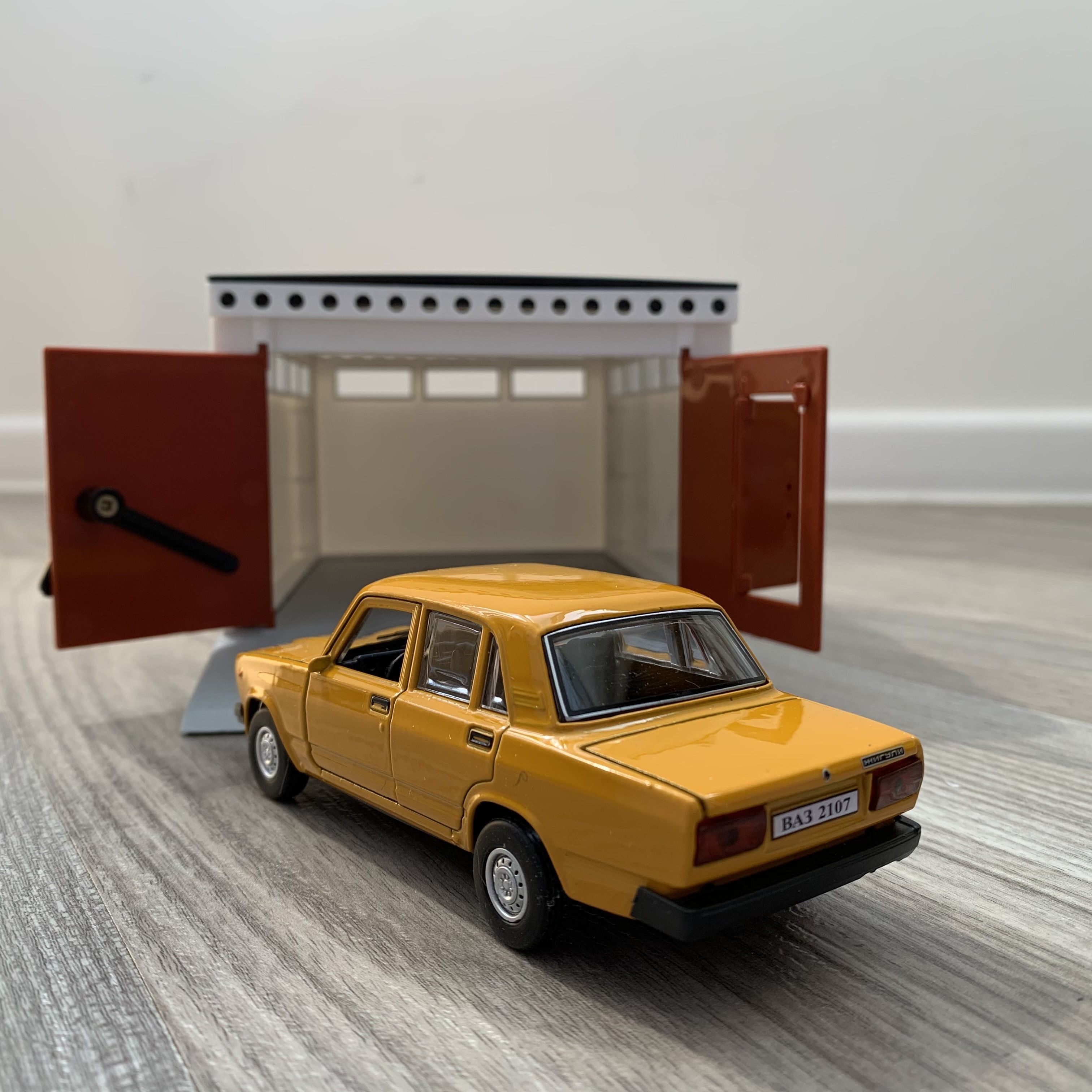 Гараж с распашными воротами и металлическая машинка 12 см модель ВАЗ 2107 инерция, 2 откр. двери и багажник - оранжевая
