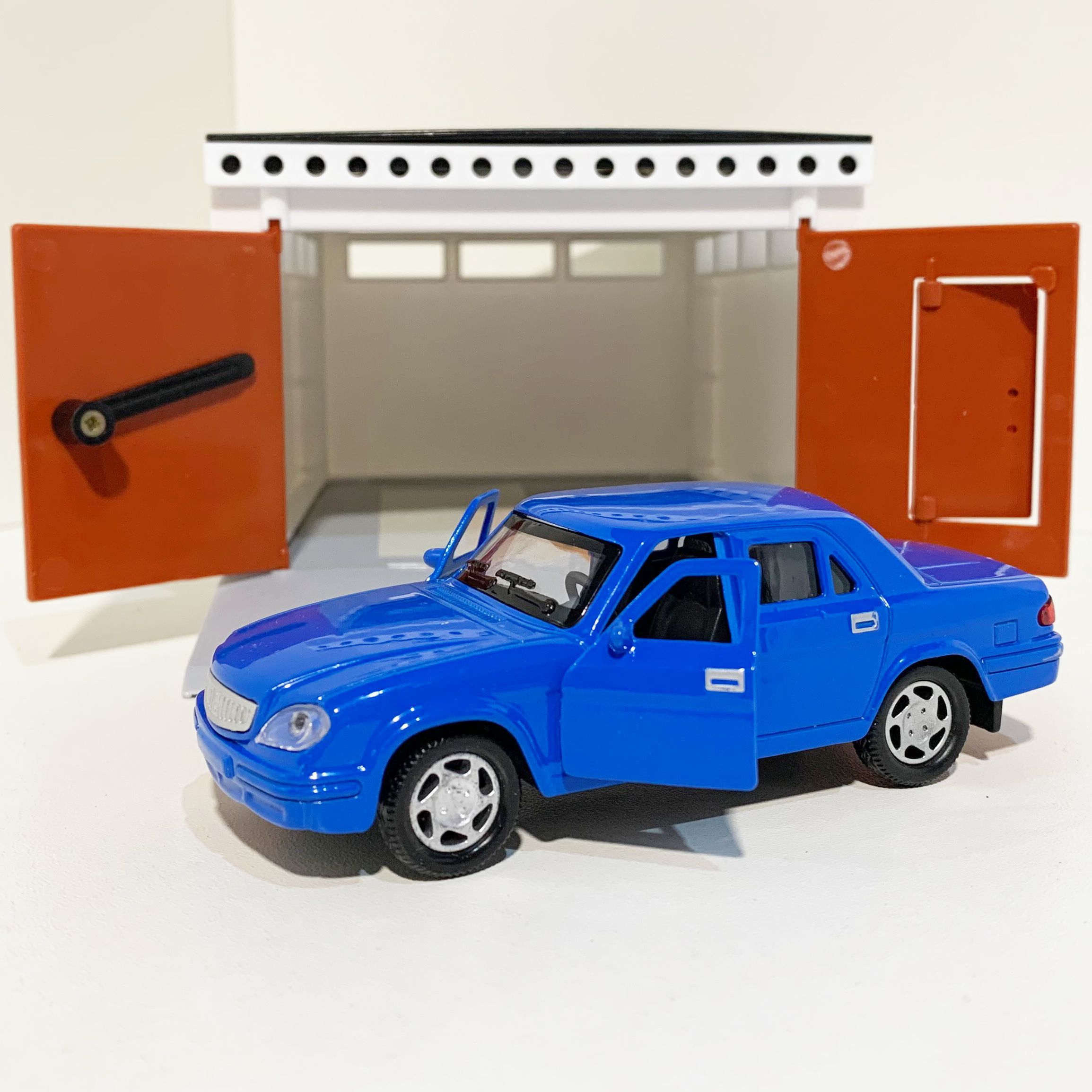 Гараж с распашными воротами и металлическая инерционная машинка Волга 3110 с 2-мя открывающимися дверями 12 см - голубая