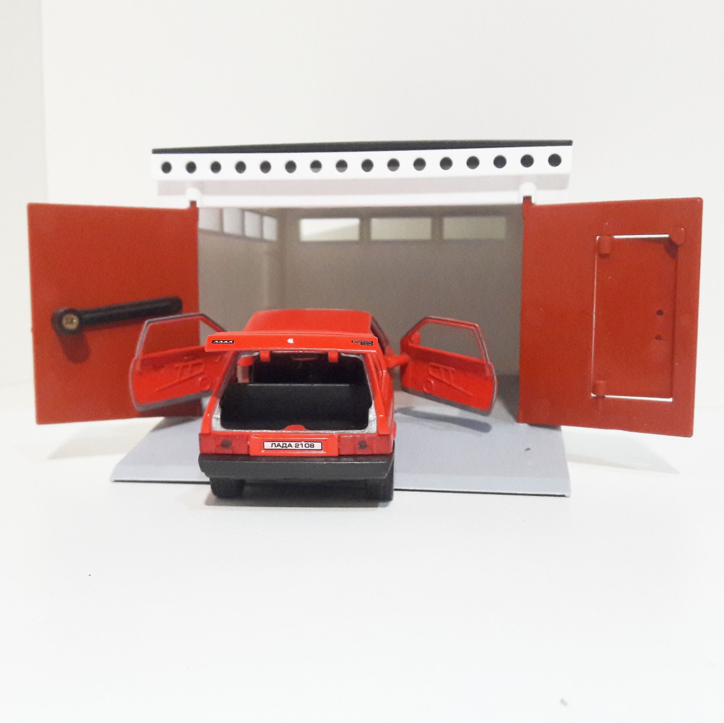 Гараж разборный и металлическая машинка 12 см с инерционным механизмом и открывающимися дверями ярко-красная