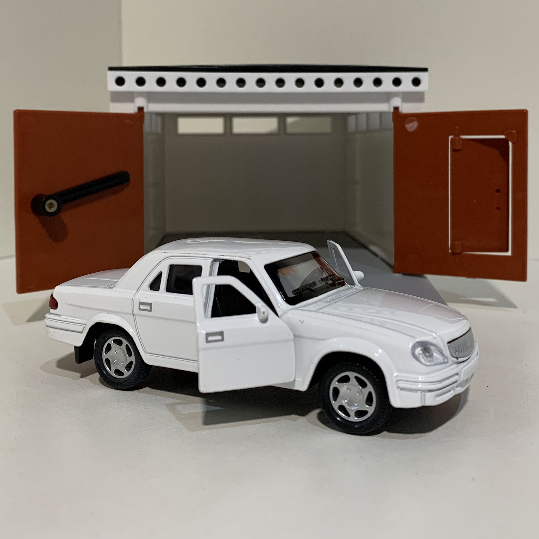 Гаражный бокс с распашными воротами и металлическая инерционная машинка Волга 3110 с открывающимися дверями 12 см - белая