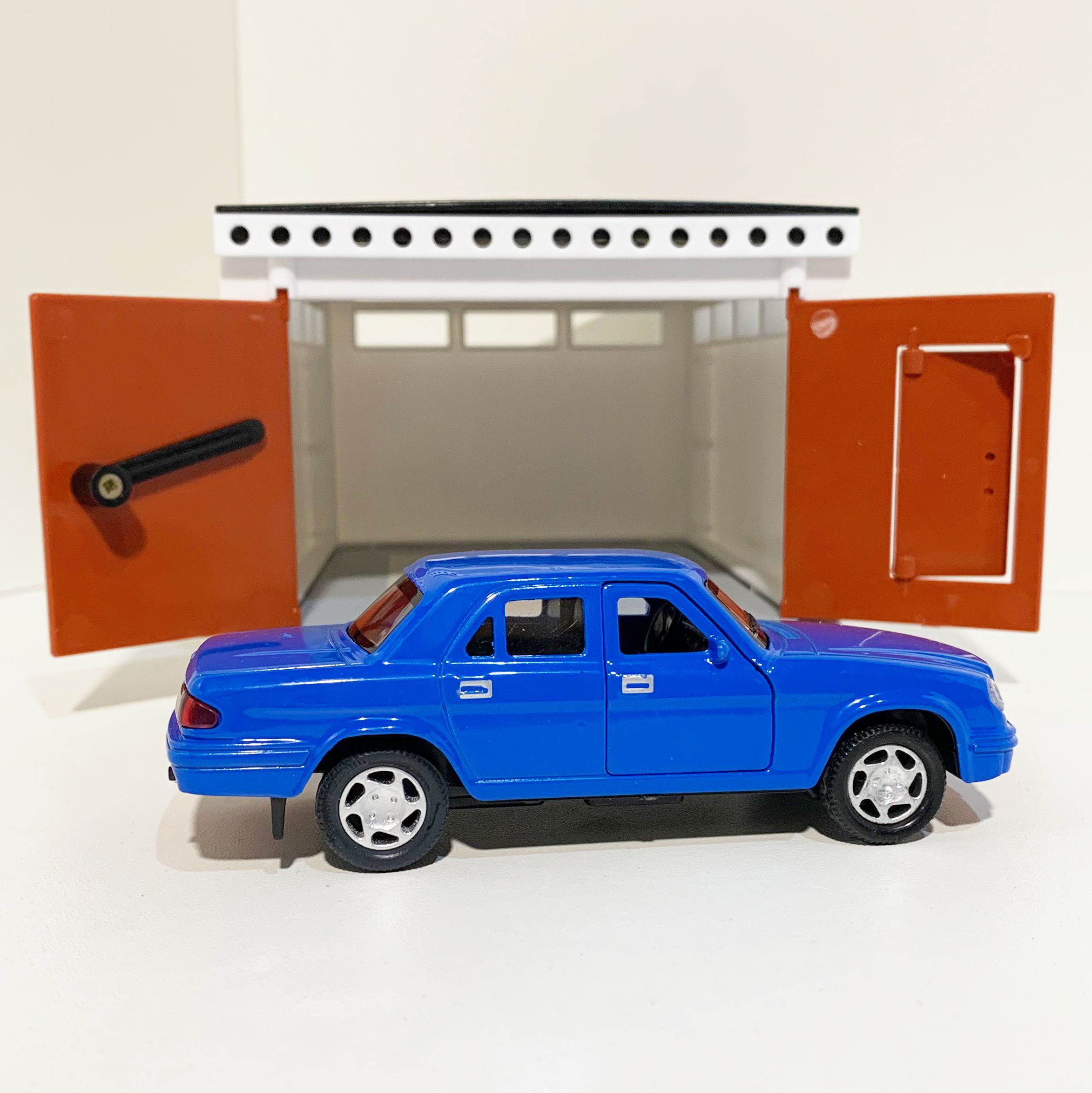 Гараж с распашными воротами и металлическая инерционная машинка Волга 3110 с 2-мя открывающимися дверями 12 см - голубая