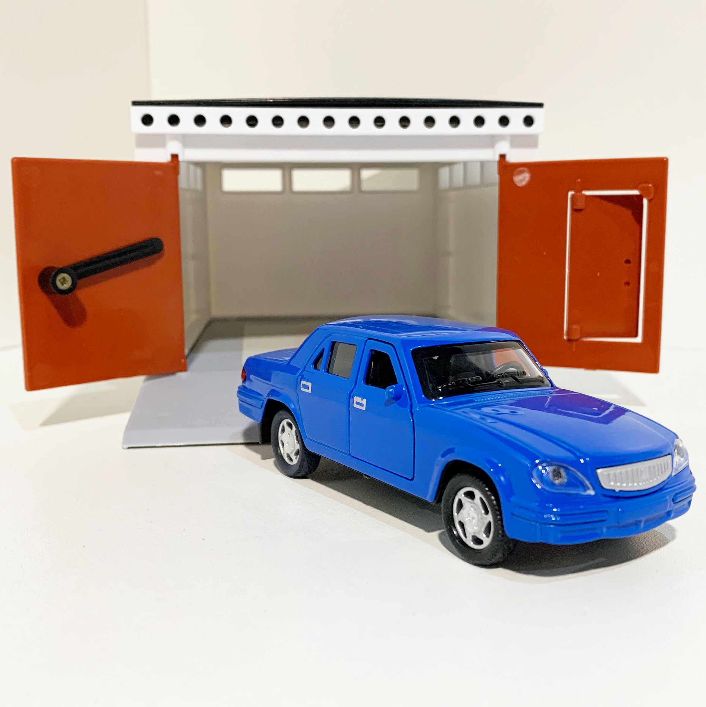 Гараж с распашными воротами и металлическая инерционная машинка Волга 3110 с 2-мя открывающимися дверями 12 см - голубая