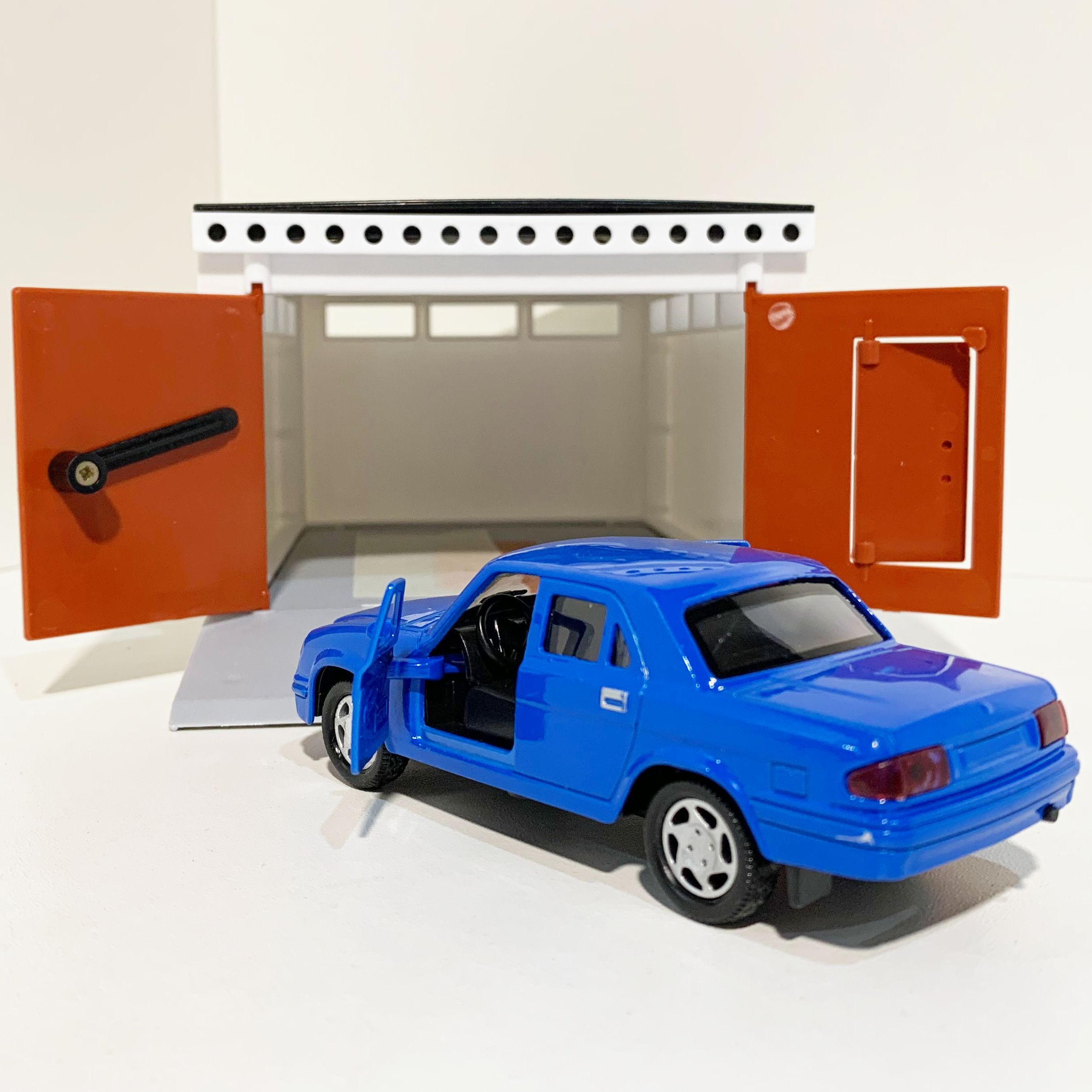 Гараж с распашными воротами и металлическая инерционная машинка Волга 3110 с 2-мя открывающимися дверями 12 см - голубая