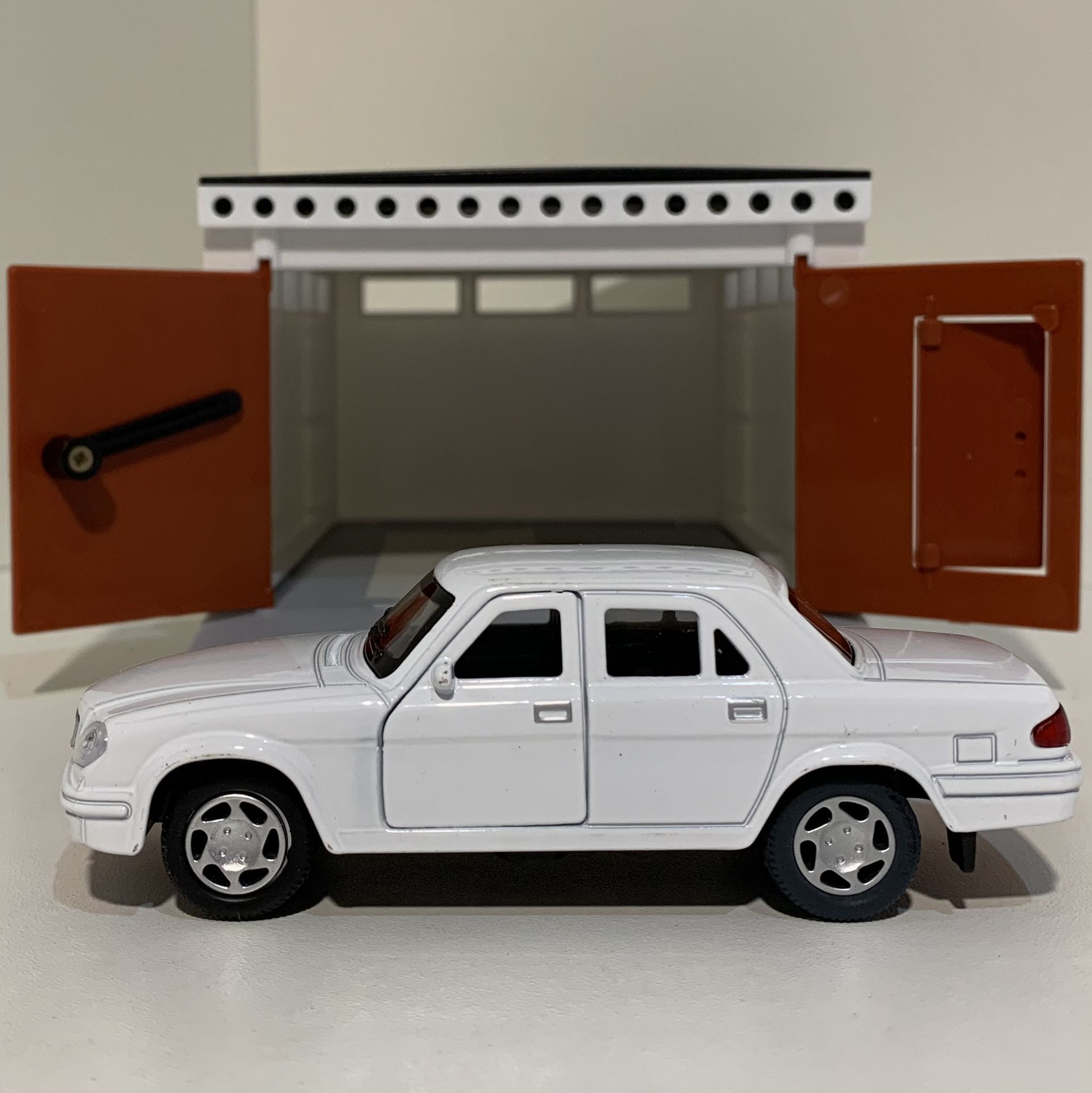 Гаражный бокс с распашными воротами и металлическая инерционная машинка Волга 3110 с открывающимися дверями 12 см - белая