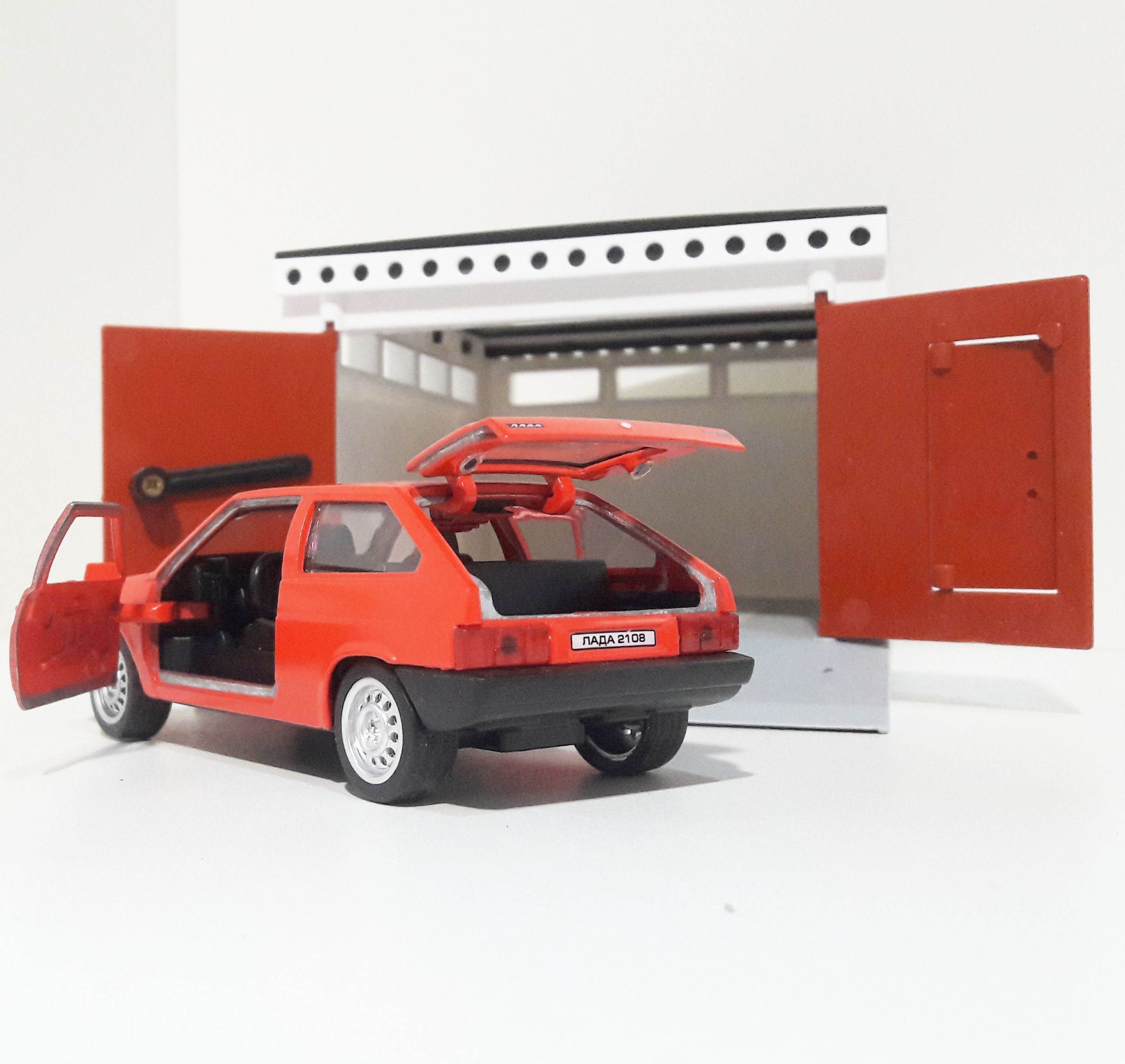 Гараж разборный и металлическая машинка 12 см с инерционным механизмом и открывающимися дверями ярко-красная