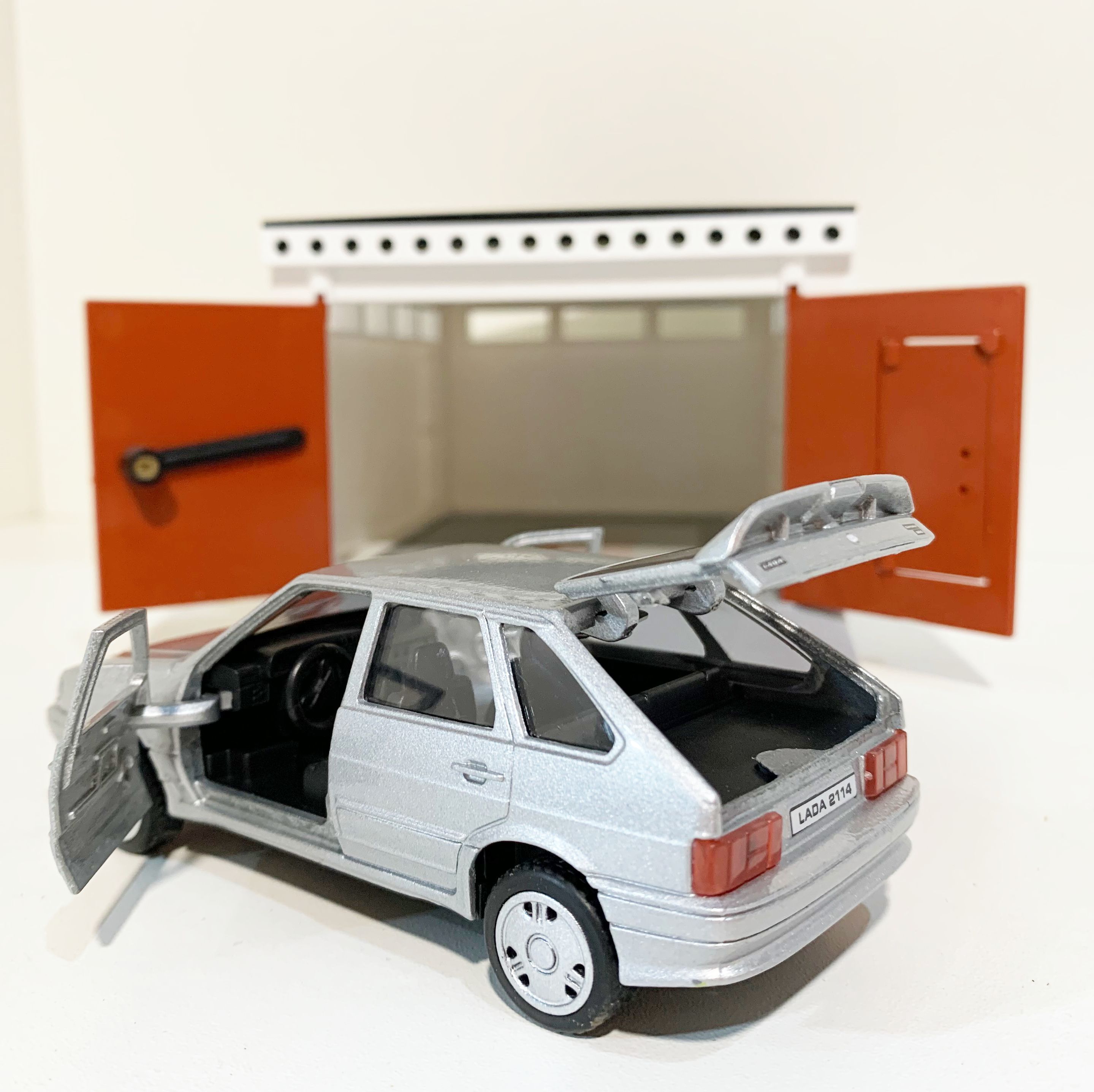 Гараж с распашными воротами и металлическая инерционная машинка ВАЗ 2114 с открывающимися дверями и багажником серебристая
