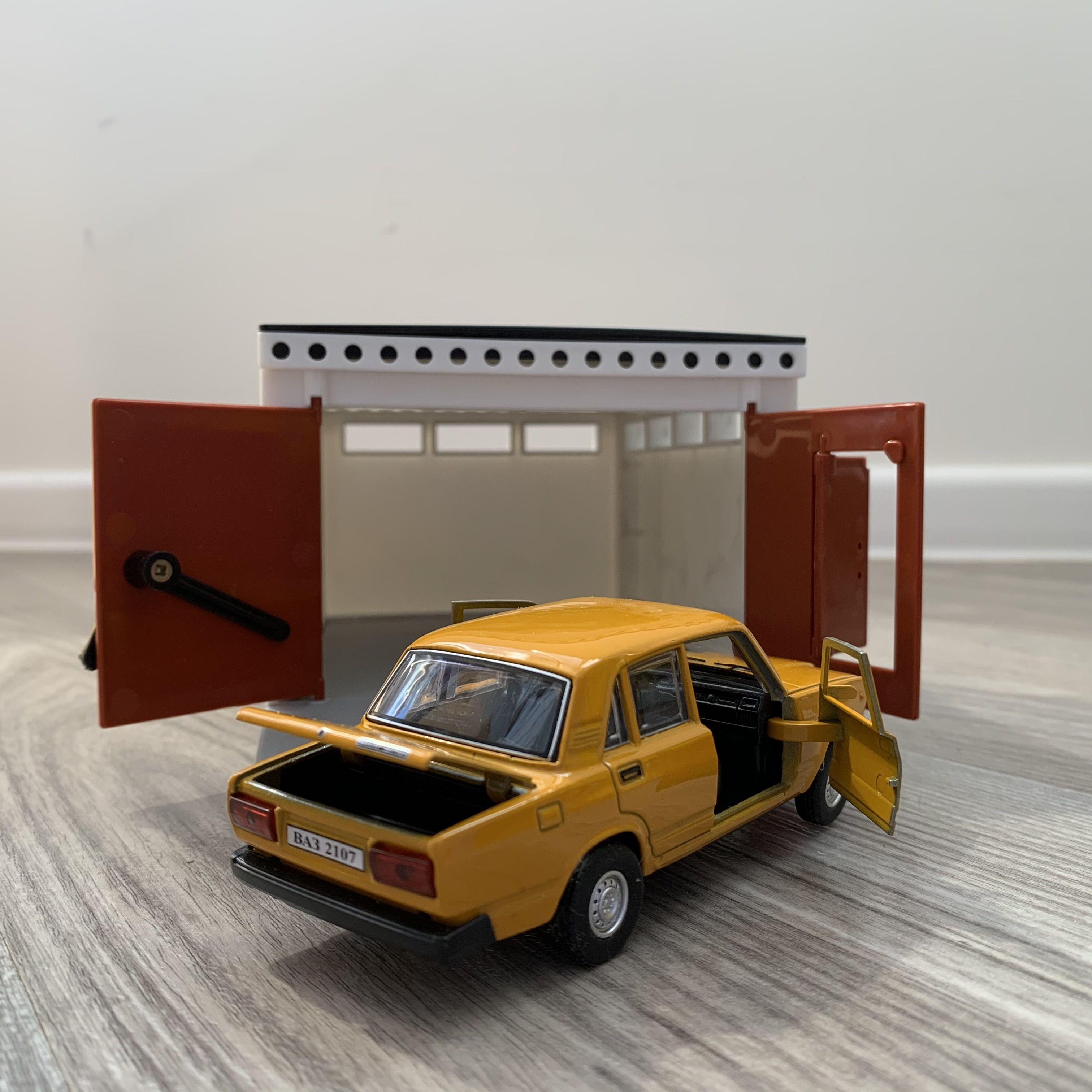 Гараж с распашными воротами и металлическая машинка 12 см модель ВАЗ 2107 инерция, 2 откр. двери и багажник - оранжевая
